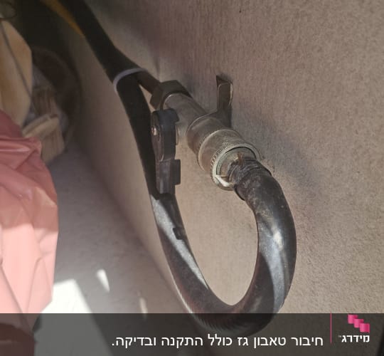 צינור גז מחובר לשסתום מתכת על קיר